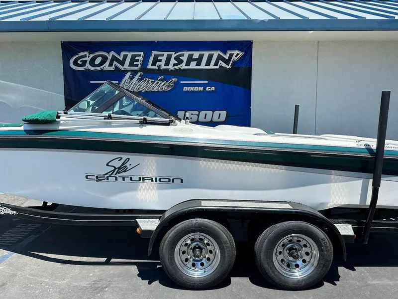 Slide: The Image of 1998 Ski Centurion sport bowrider on trailer, parked near "Gone Fishin'" sign. - 6