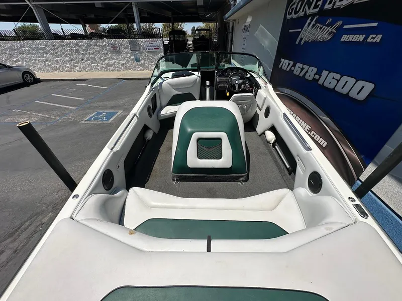 Slide: The Image of 1998 Ski Centurion sport bowrider interior with green and white seating, parked outdoors. - 9