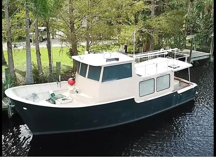 The Image of 1965 Romsdal Fjord boat docked by lush trees on a calm river. - 1