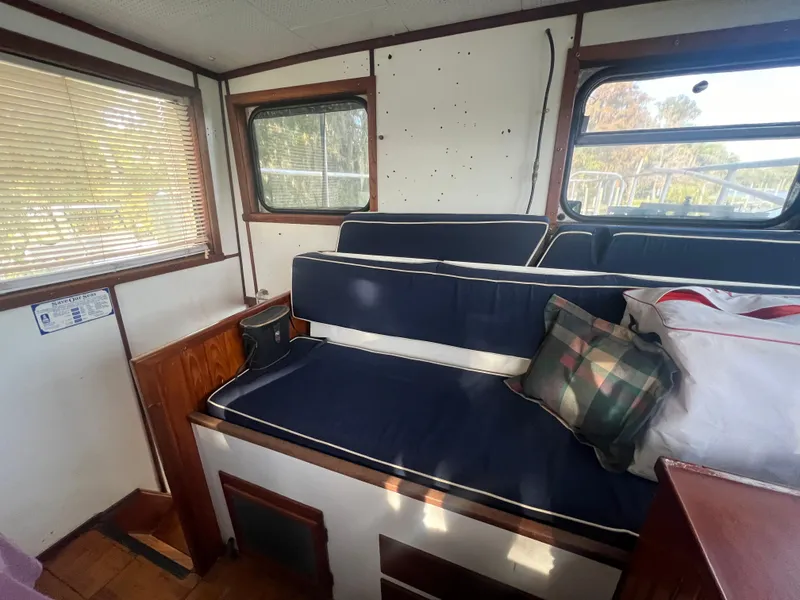 Slide: The Image of Interior of a 1965 Romsdal Fjord boat with blue seating and plaid pillow. - 10
