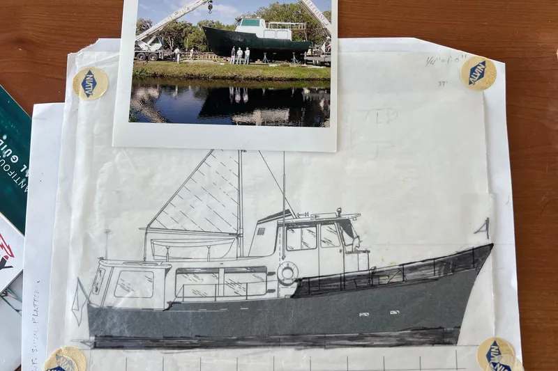 Slide: The Image of Blueprint and photo of 1965 Romsdal Fjord boat on wooden table. - 28