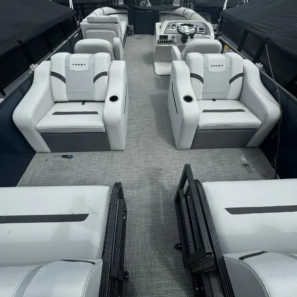 Slide: The Image of 2024 Crest Classic DLX 220 SLRC pontoon boat interior with luxurious seating and helm. - 5