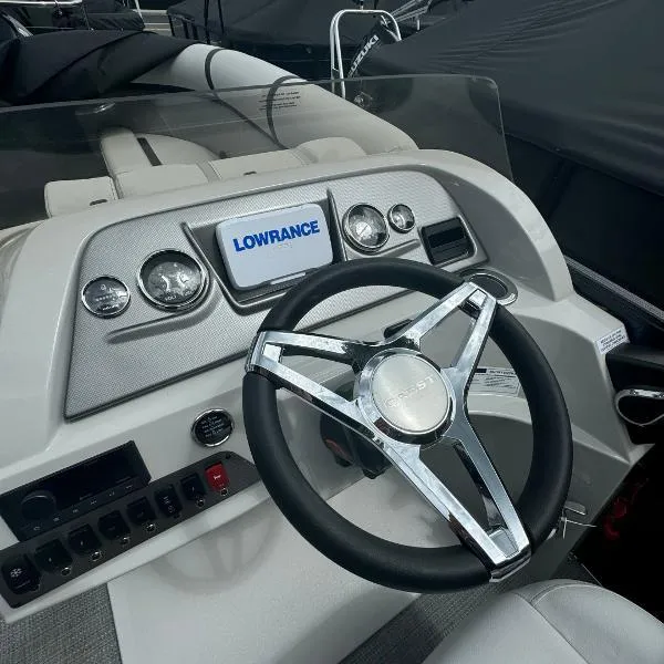 Slide: The Image of 2024 Crest Classic DLX 220 SLRC boat dashboard with Lowrance display and steering wheel. - 6