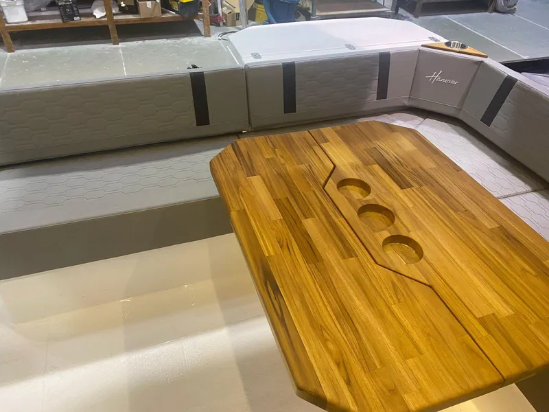Slide: The Image of Luxurious Hanover 387 boat interior with wooden table and gray seating, 2025 model. - 2