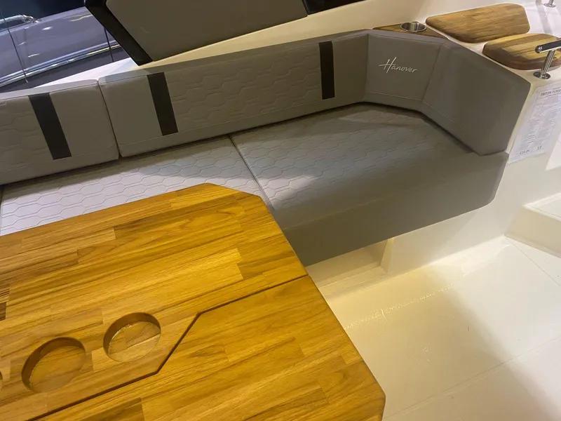 Slide: The Image of 2025 Hanover 387 boat interior with gray seating and wooden table. - 3
