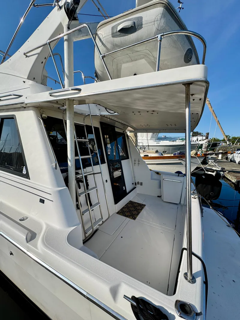 Slide: The Image of 1997 Bayliner 3988 Motor Yacht docked, showcasing spacious deck and flybridge. - 2