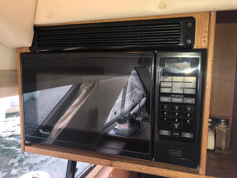 Slide: The Image of Microwave inside 1997 Bayliner 3988 Motor Yacht, featuring wood trim and digital controls. - 20