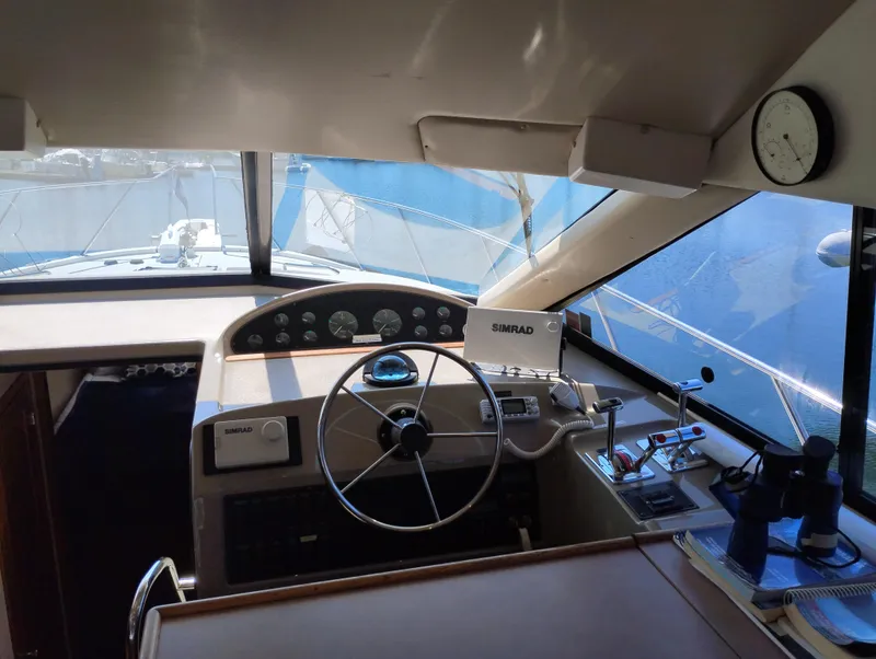 Slide: The Image of 1997 Bayliner 3988 Motor Yacht helm with steering wheel, navigation equipment, and gauges. - 25