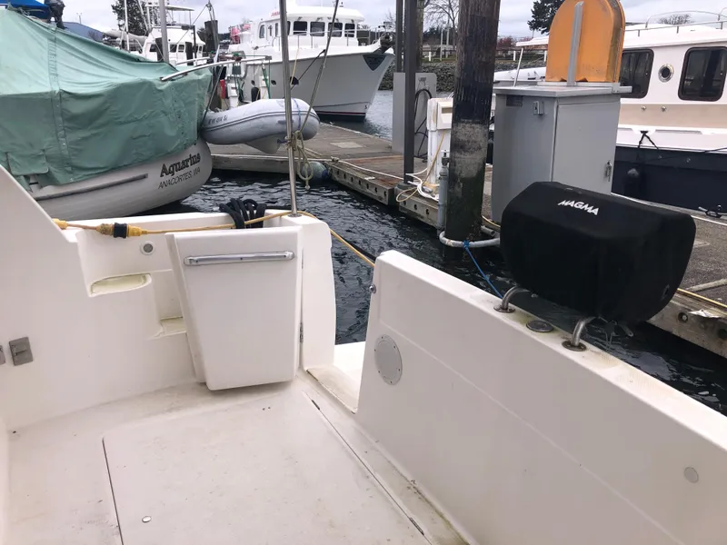 Slide: The Image of 1997 Bayliner 3988 Motor Yacht docked, featuring outdoor seating and a covered grill. - 3