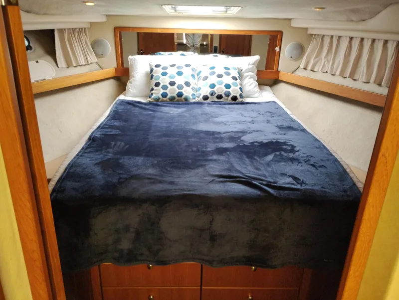 Slide: The Image of Cozy bedroom in 1997 Bayliner 3988 Motor Yacht with plush bedding and wooden accents. - 31