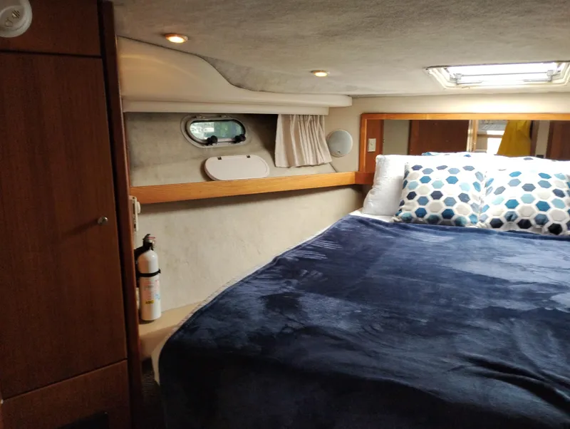 Slide: The Image of Cozy bedroom in 1997 Bayliner 3988 Motor Yacht with blue bedding and porthole window. - 32
