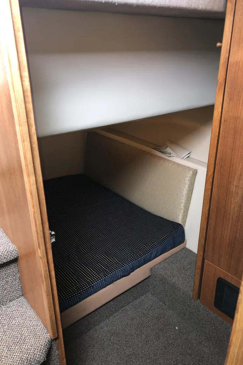 Slide: The Image of 1997 Bayliner 3988 Motor Yacht interior cabin with bunk beds and carpeted flooring. - 38