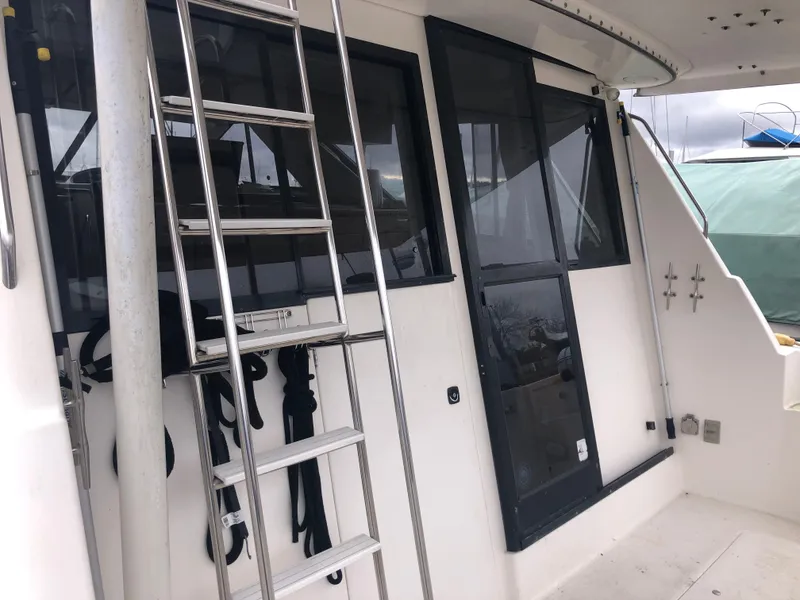 Slide: The Image of 1997 Bayliner 3988 Motor Yacht exterior with ladder and windows, showcasing sleek design. - 4