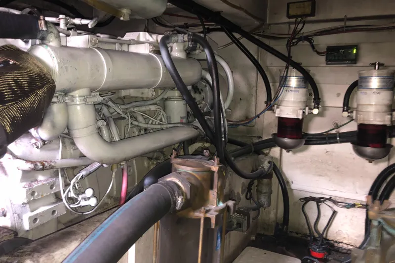 Slide: The Image of Engine room of 1997 Bayliner 3988 Motor Yacht with visible pipes and wiring. - 42