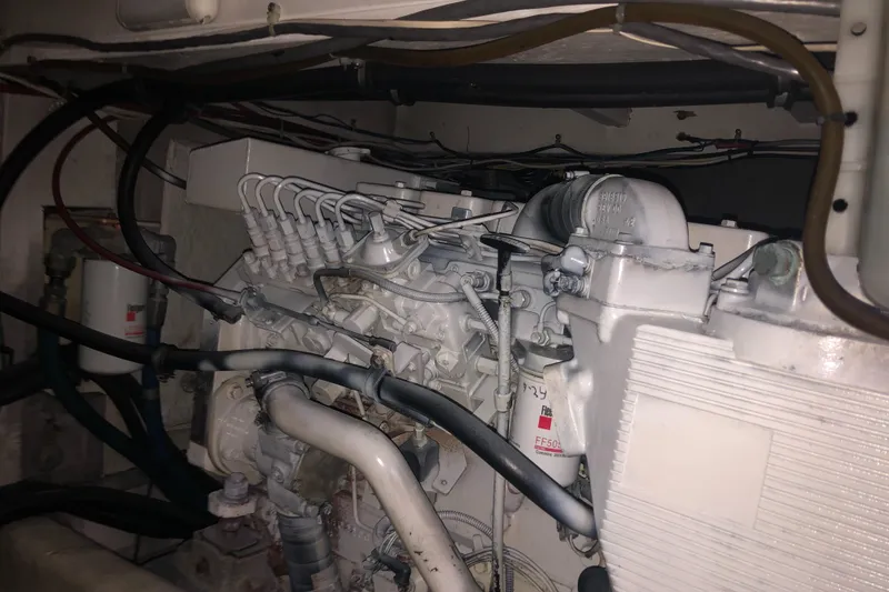 Slide: The Image of Engine compartment of a 1997 Bayliner 3988 Motor Yacht, showcasing mechanical components and wiring. - 43