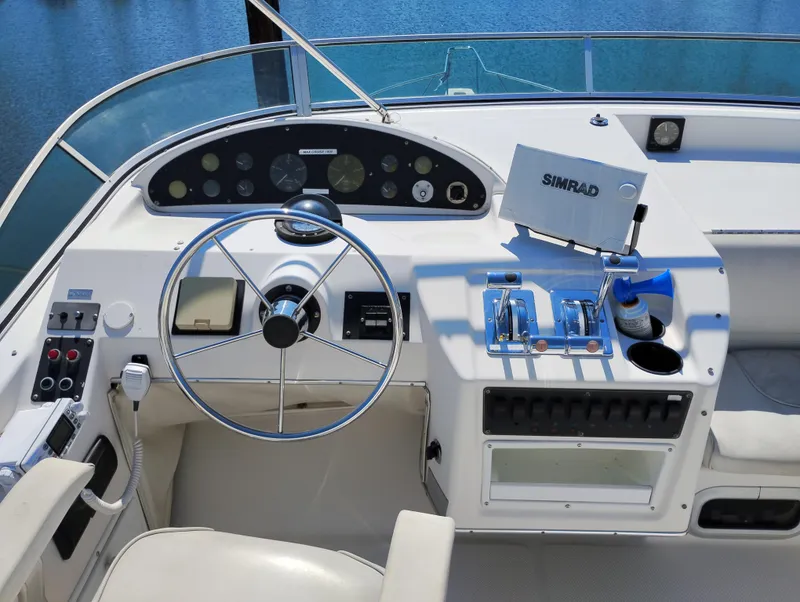 Slide: The Image of 1997 Bayliner 3988 Motor Yacht helm with steering wheel, controls, and Simrad navigation system. - 6