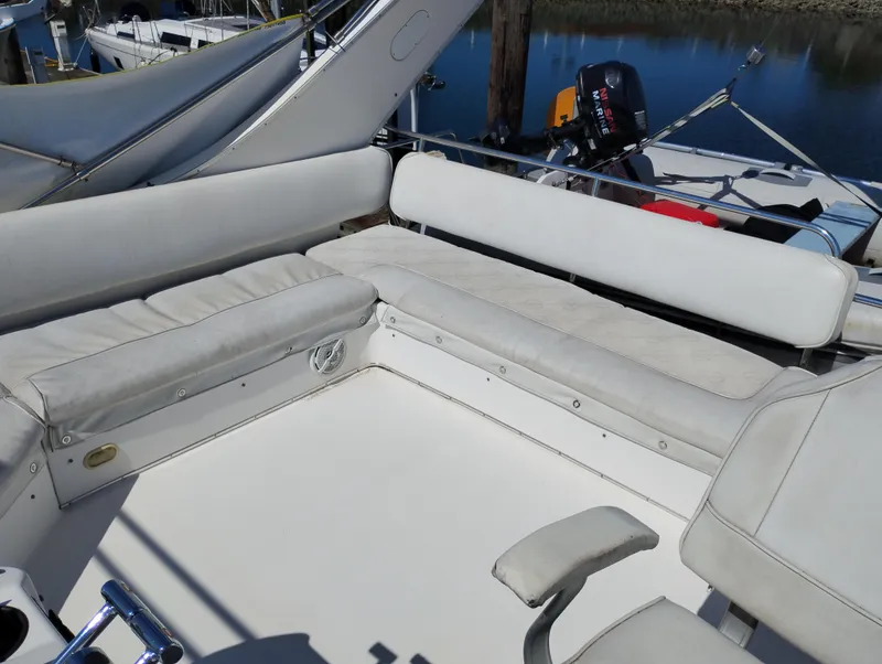 Slide: The Image of 1997 Bayliner 3988 Motor Yacht seating area with white cushions and outdoor setting. - 8