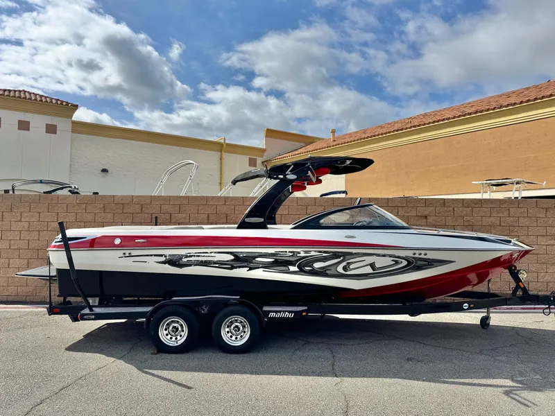 Slide: The Image of 2007 Malibu Wakesetter 247 LSV boat on trailer, red and black design, parked outdoors. - 0
