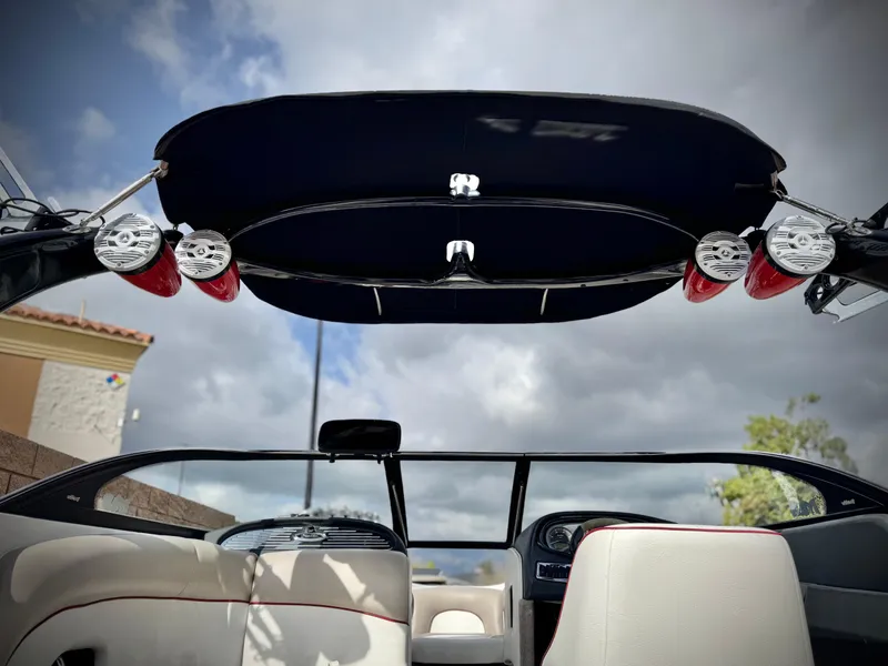 Slide: The Image of 2007 Malibu Wakesetter 247 LSV boat interior with speakers and canopy under cloudy sky. - 20