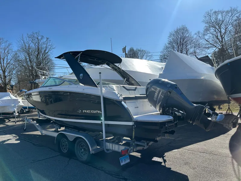 Slide: The Image of 2018 Regal 23 OBX boat on trailer, parked outdoors under clear blue sky. - 2