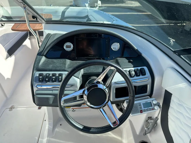 Slide: The Image of 2018 Regal 23 OBX boat dashboard with steering wheel and control panel. - 26