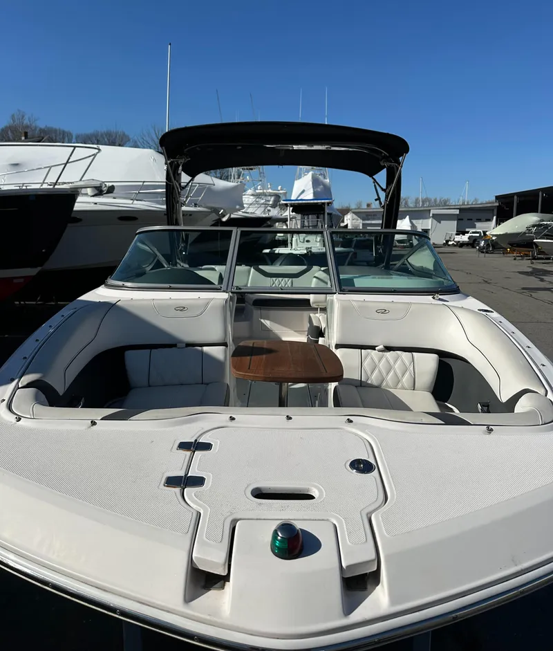 Slide: The Image of 2018 Regal 23 OBX boat with spacious seating and sleek design in a marina setting. - 34