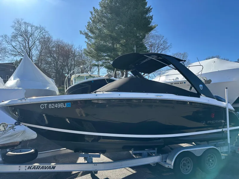 Slide: The Image of 2018 Regal 23 OBX boat on trailer, parked outdoors under clear sky. - 35