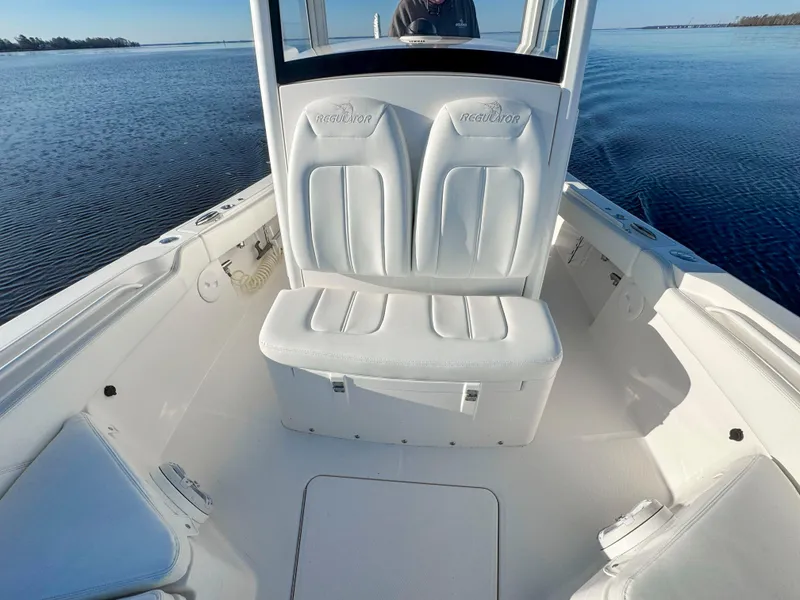 Slide: The Image of 2022 Regulator 24 XO boat interior with white seating on calm water. - 11