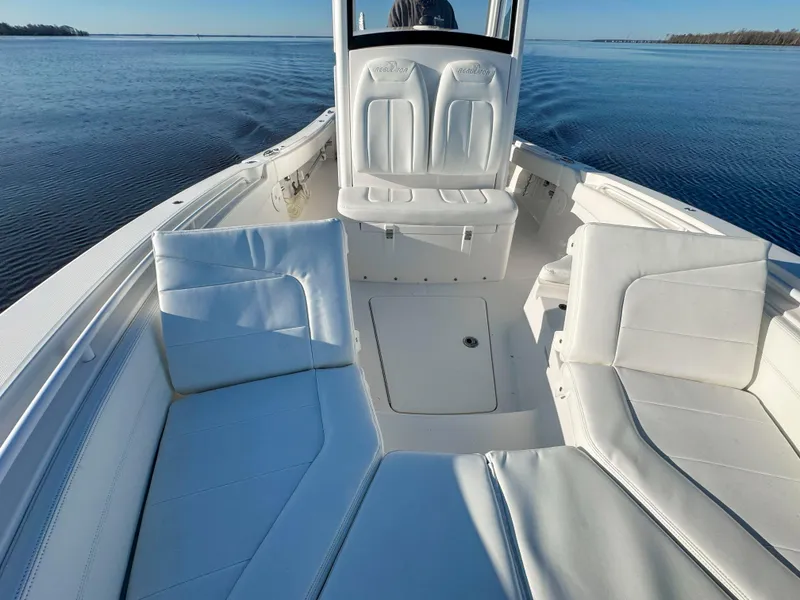 Slide: The Image of 2022 Regulator 24 XO boat interior with white seating on calm water. - 12
