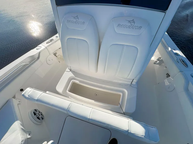 Slide: The Image of 2022 Regulator 24 XO boat interior with white seating and storage compartment. - 16