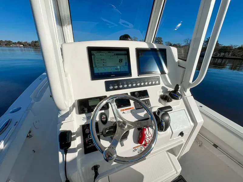 Slide: The Image of 2022 Regulator 24 XO boat dashboard with steering wheel and navigation screens. - 18