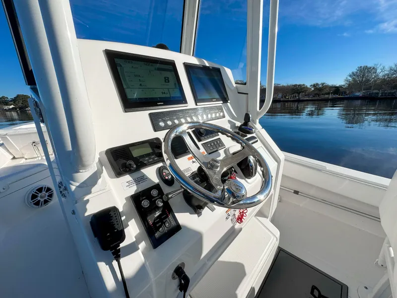 Slide: The Image of 2022 Regulator 24 XO boat dashboard with steering wheel and navigation screens. - 20