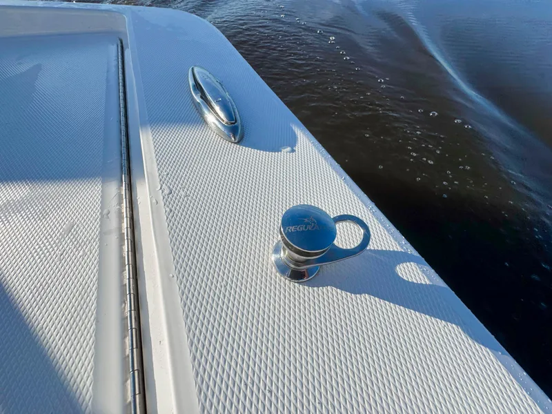 Slide: The Image of 2022 Regulator 24 XO boat deck with cleat and textured surface near water. - 22