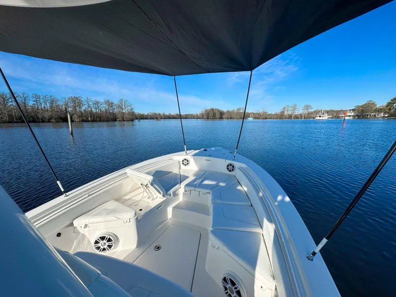 Slide: The Image of 2022 Regulator 24 XO boat on calm lake under clear blue sky. - 23