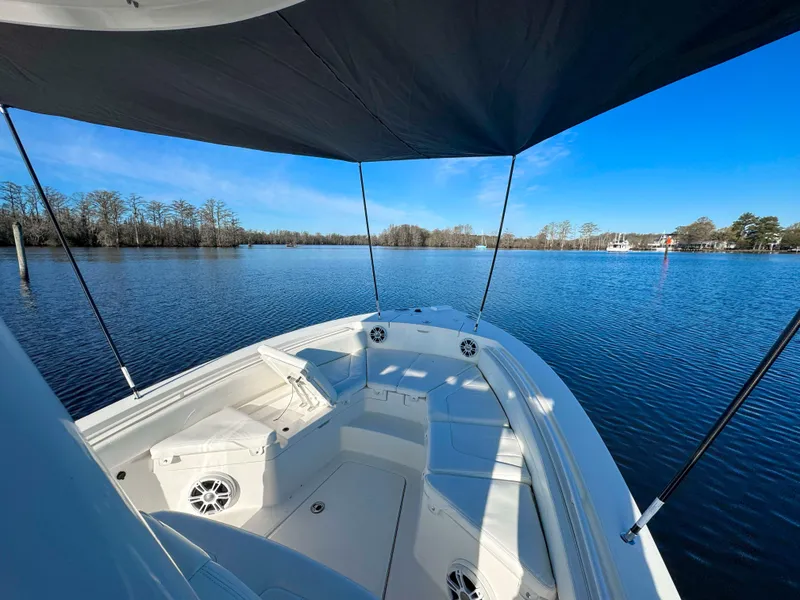 Slide: The Image of 2022 Regulator 24 XO boat on calm lake under blue sky. - 24