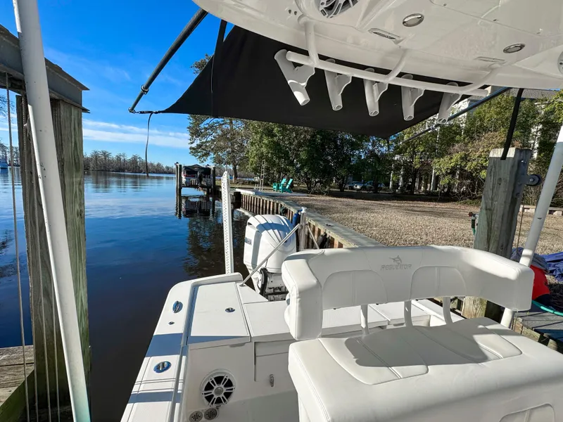 Slide: The Image of 2022 Regulator 24 XO boat docked by a serene waterfront with clear blue skies. - 25