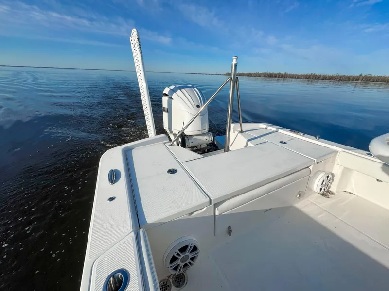 Slide: The Image of 2022 Regulator 24 XO boat on calm water, showcasing deck and motor. - 3