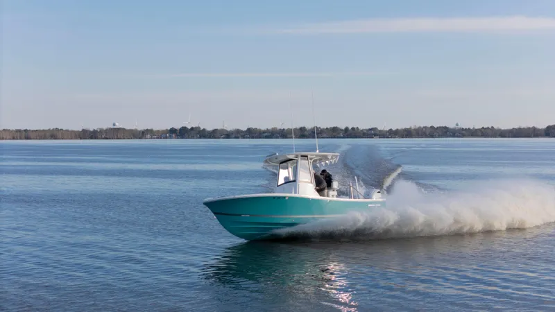 Slide: The Image of 2022 Regulator 24 XO boat cruising on a calm lake under a clear sky. - 31