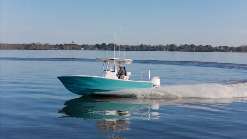 Slide: The Image of 2022 Regulator 24 XO boat cruising on calm water, side view. - 34