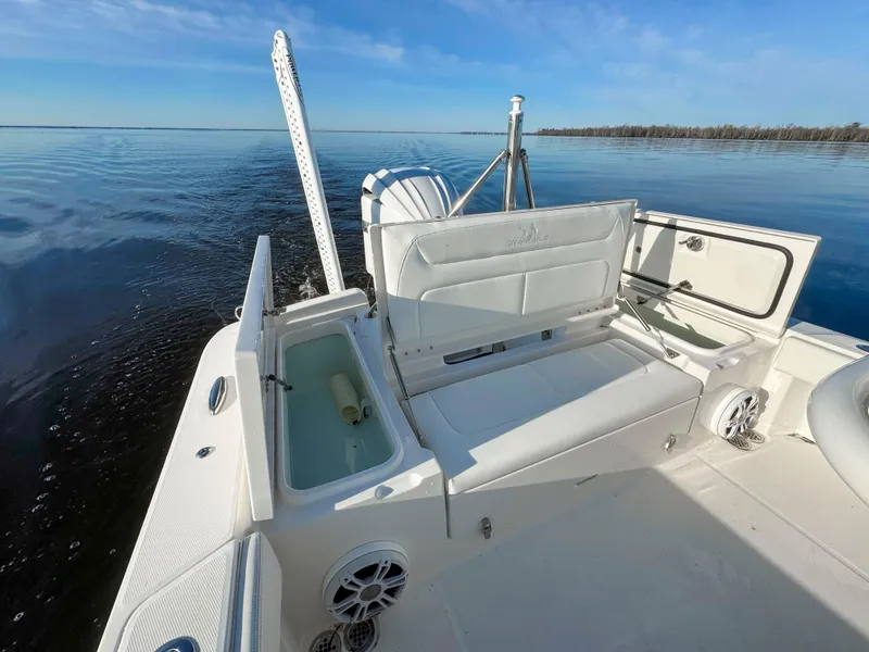 Slide: The Image of 2022 Regulator 24 XO boat interior with open storage, on calm water under blue sky. - 6