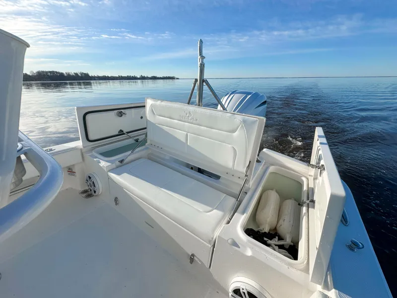 Slide: The Image of 2022 Regulator 24 XO boat interior with open storage compartments on calm water. - 7