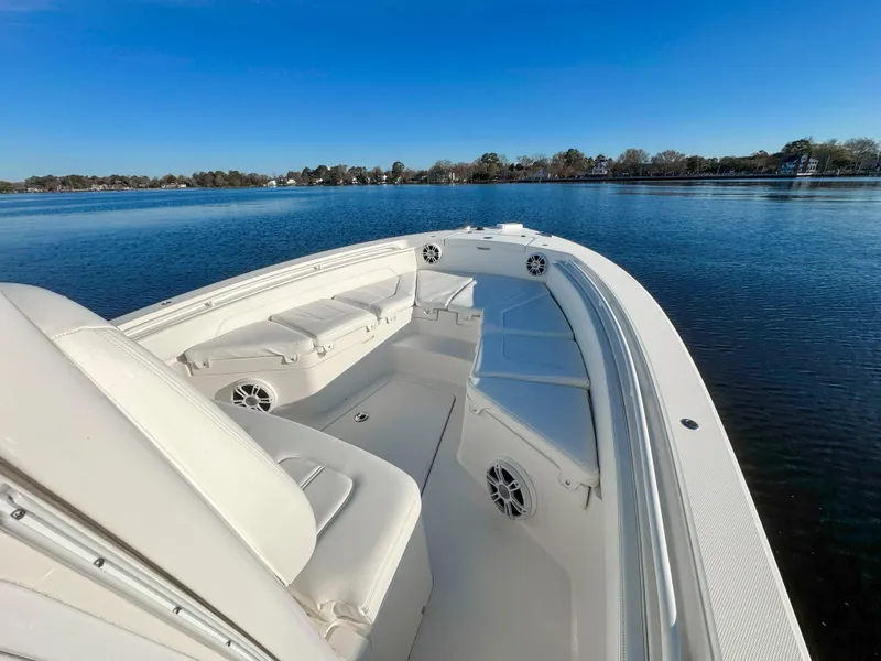 Slide: The Image of 2022 Regulator 24 XO boat on calm water, featuring spacious seating and sleek design. - 9