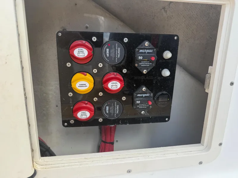 Slide: The Image of Electrical panel on a 1999 Boston Whaler 28 Conquest boat, featuring circuit breakers and switches. - 11