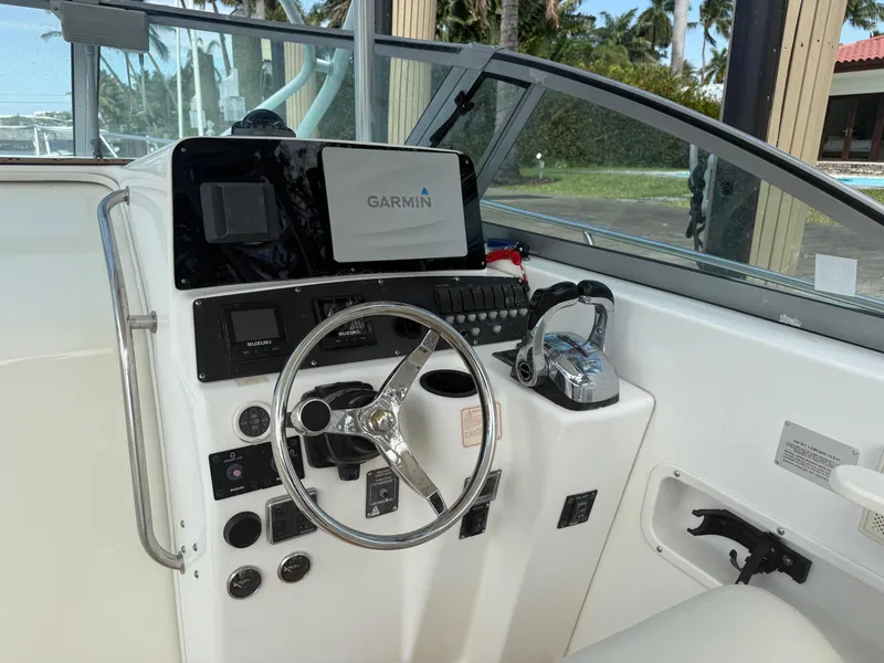Slide: The Image of 1999 Boston Whaler 28 Conquest helm with Garmin navigation system and steering wheel. - 12