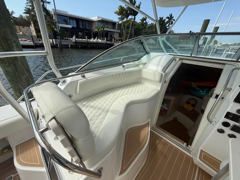 Slide: The Image of 1999 Boston Whaler 28 Conquest boat interior with seating and cabin entrance. - 13