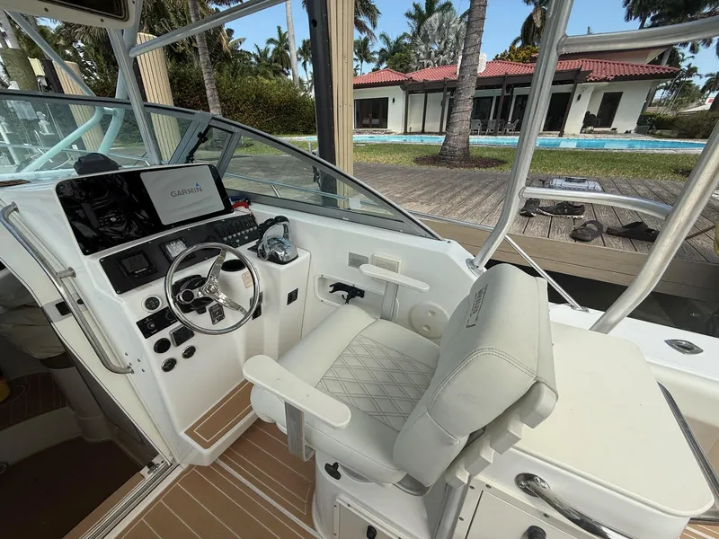 Slide: The Image of 1999 Boston Whaler 28 Conquest helm with modern controls and luxurious seating. - 14