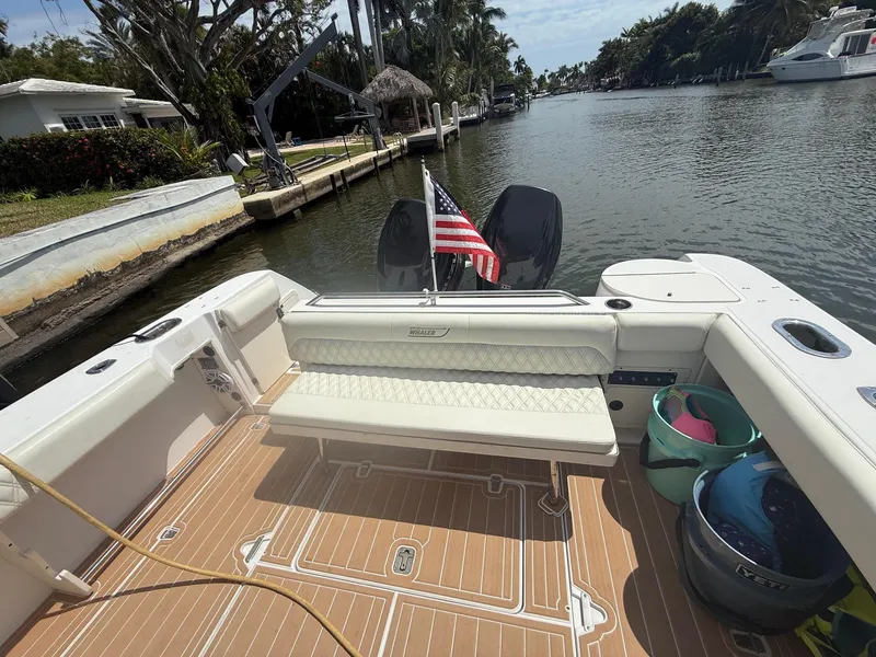 Slide: The Image of 1999 Boston Whaler 28 Conquest boat with American flag, docked on a scenic canal. - 15