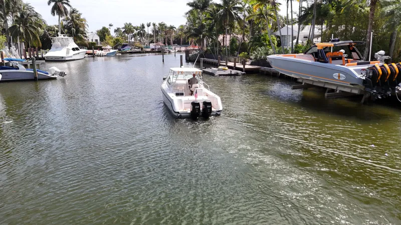 Slide: The Image of 1999 Boston Whaler 28 Conquest cruising in a scenic, palm-lined waterway. - 20