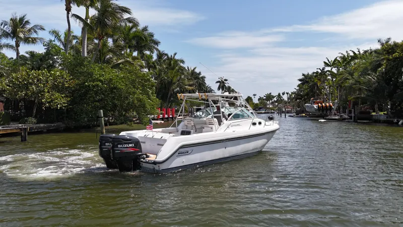 Slide: The Image of 1999 Boston Whaler 28 Conquest boat cruising on a scenic, tropical waterway. - 29