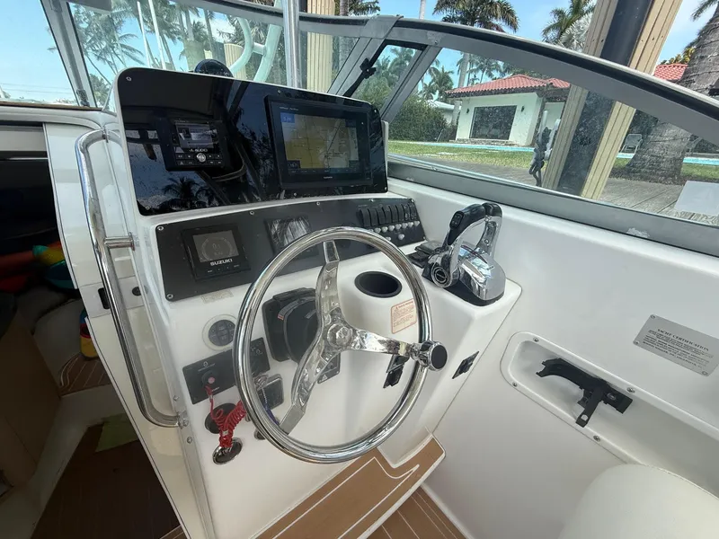 Slide: The Image of 1999 Boston Whaler 28 Conquest helm with steering wheel and navigation controls. - 3